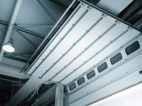 Automatic sectional door seen from inside the industrial hall