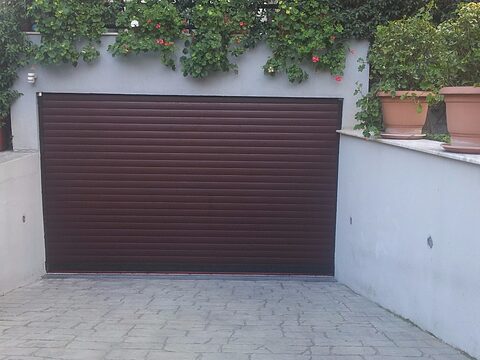 Dark red garage door in the wall of a house